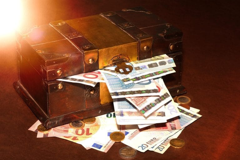 Vintage wooden treasure chest overflowing with euro banknotes and gold coins, symbolizing wealth, investment, and financial success.